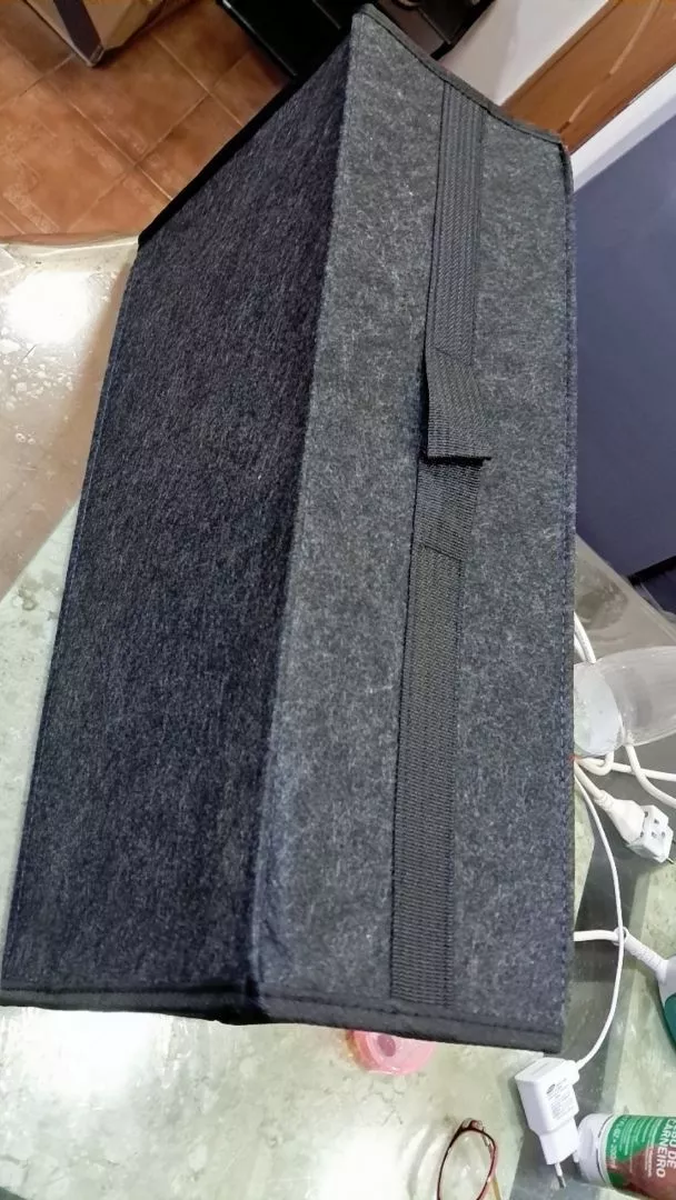 Foto de cliente: organizador montado e fechado sobre uma mesa, mostrando as laterais firmes e a alça no tampo